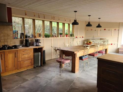 une cuisine avec une grande table et des chaises en bois dans l'établissement La caronnière, à Mervent