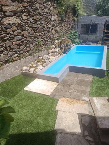a large blue swimming pool in a yard with grass at Casa do Forno FR in Mondim de Basto