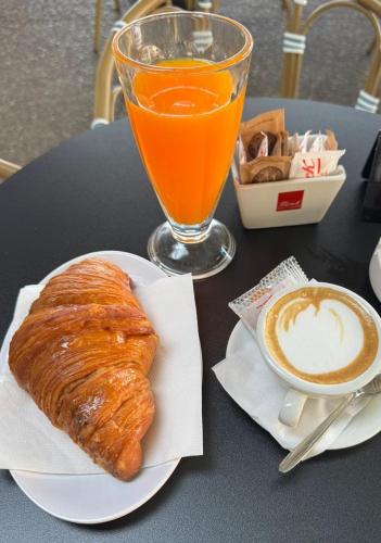 a plate with a pastry and a drink on a table at Alba Suites in Vlorë