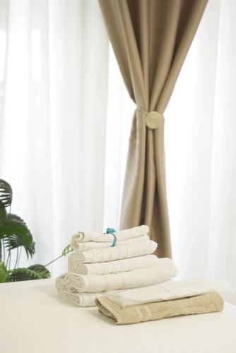 a stack of towels on a table with a window at Central C3 studio in Volos