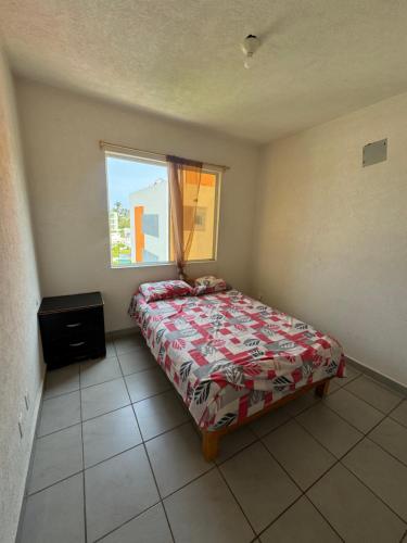 a small bedroom with a bed and a window at Hermoso Departamento económico y alberca in La Sabana