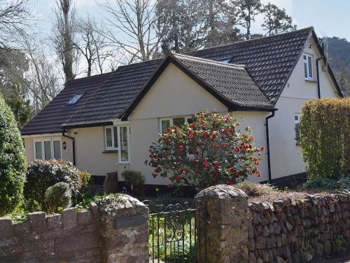 a white house with a black roof and a fence at Mill Haven in Dunster