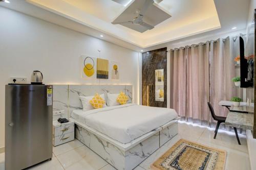 a bedroom with a bed and a desk in it at Luxury Studio Apartment with Kitchenette & Private Balcony ,Gurugram in Gurgaon