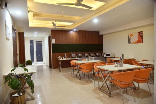 a dining room with tables and chairs in a restaurant at Luxury Studio Apartment with Kitchenette & Private Balcony ,Gurugram in Gurgaon