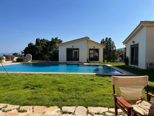 a yard with a chair and a swimming pool at West Pool House in Kineta