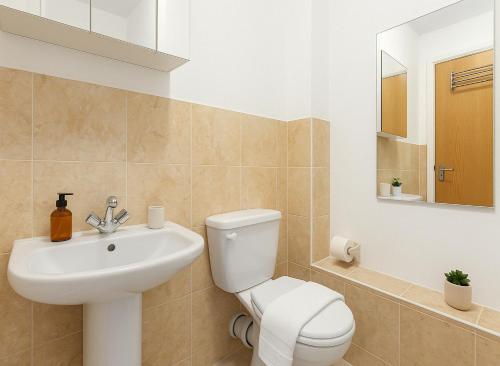 Un baño con un inodoro blanco y un lavabo. en Modern Flat near Tower Bridge, en Londres