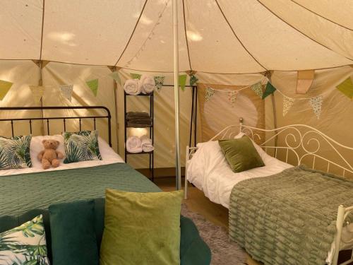 a tent with two beds and a teddy bear on it at Luxury Glamping The Wye Valley for 2 to 4 Guests in Ross on Wye