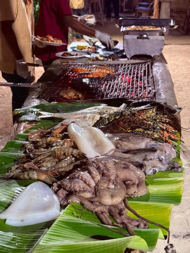 a bunch of different types of food on a grill at Maisha Nungwi - Boutique Hotel in Nungwi