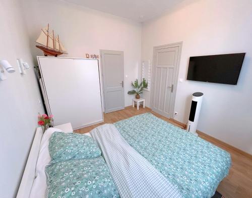 une chambre avec un lit et une télévision à écran plat dans l'établissement Maison Dijon, à Dijon