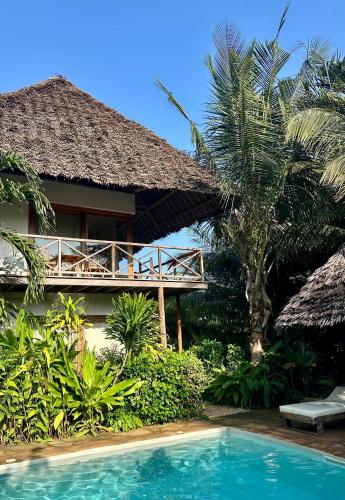a resort with a swimming pool next to a building at Maisha Nungwi - Boutique Hotel in Nungwi