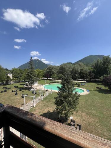 a view from a balcony of a park with a pool at Hotel Verdeneve in Opi