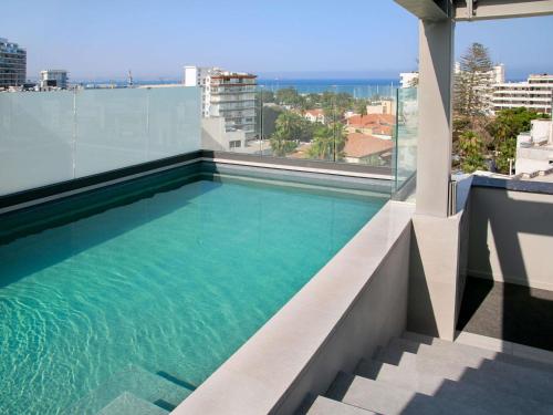 a swimming pool on the roof of a building at Mercure Larnaca Finikoudes Beach in Larnaka