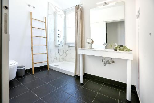 a bathroom with a sink and a shower and a mirror at Salty Spot Apartment in Faro