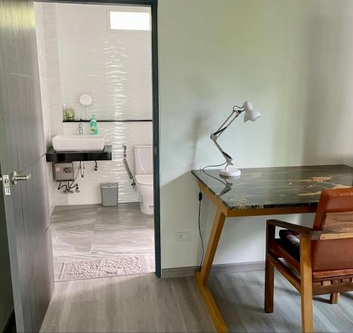 a bathroom with a desk with a sink and a toilet at Jampun Pool Villa in Klong Muang Beach