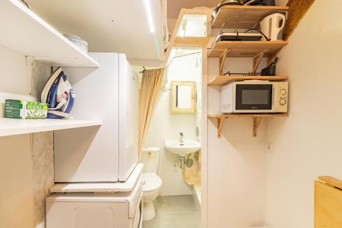 La petite salle de bains est pourvue de toilettes et d'un four micro-ondes. dans l'établissement Saint Denis - Studio cosy près de la place du Châtelet, à Paris