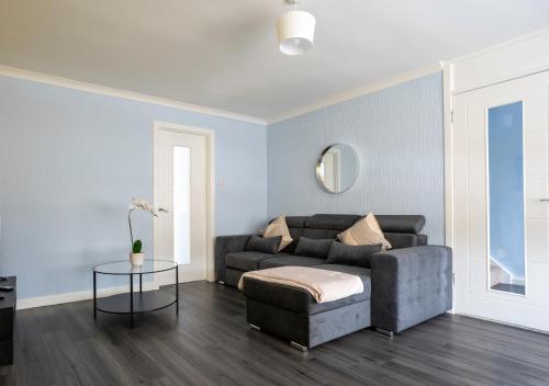 una sala de estar con un sofá y una mesa en Hillview House, en Broxburn