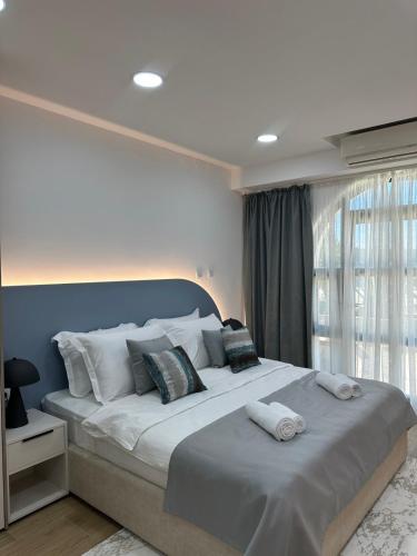 a bedroom with a large bed with towels on it at Swisslion Studios in Herceg-Novi