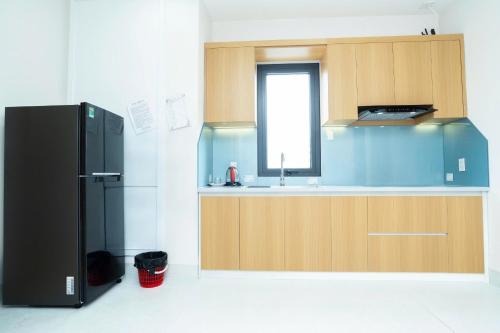 a kitchen with a black refrigerator and a sink at Chị Béo ỐC in Ha Long