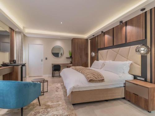 a bedroom with a large bed and a desk at Villa Reis - The Villa of Kings Hotel & Spa in Bedfordview
