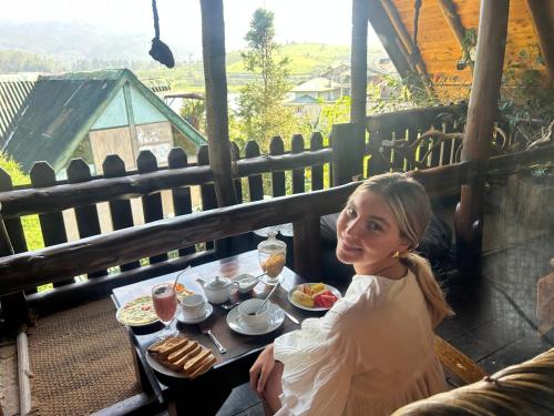 a woman sitting at a table with a plate of food at The Lake Frost in Nuwara Eliya