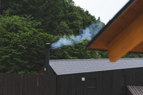 a house with smoke coming out of a roof at Earthboat Minakami Hodaigi in Minakami