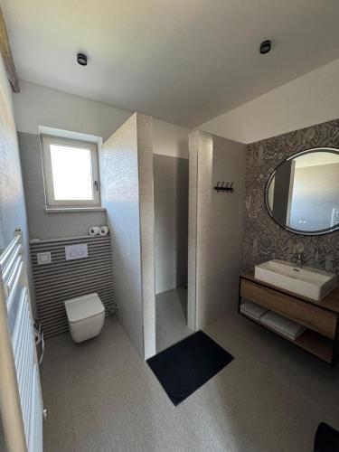 a bathroom with a toilet and a sink and a mirror at Hotel Brick House Apartments in Nitra