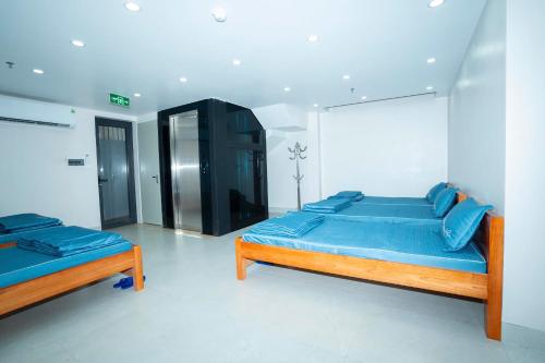 a bedroom with two beds with blue pillows at Chị Béo ỐC in Ha Long