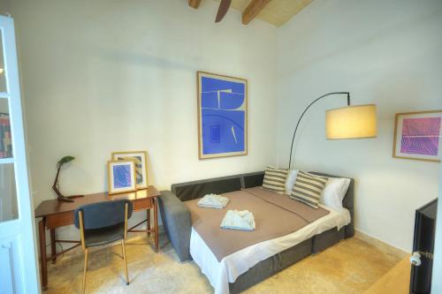 a small bedroom with a bed and a desk at Sumptuous townhouse with roof terrace AGAL1-1 in Birgu