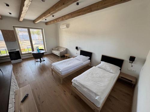 a room with two beds and a table and a couch at Hotel Brick House Apartments in Nitra