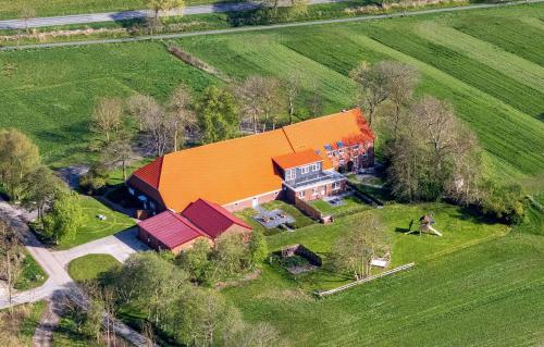 une vue aérienne sur une grande maison avec un toit orange dans l'établissement Ferienwohnung Sternstunde, à Bensersiel