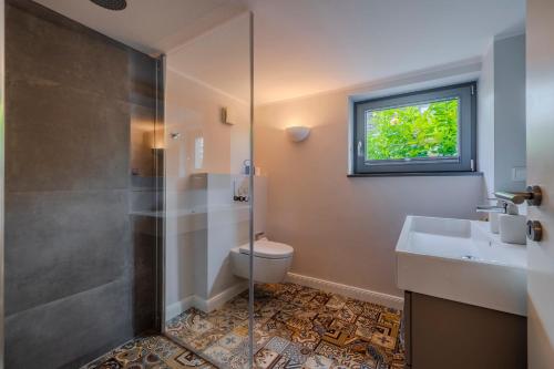 a bathroom with a shower and a toilet and a sink at Ferienhaus Wohrbarg Ferienhaus Wohrbarg in Timmendorfer Strand