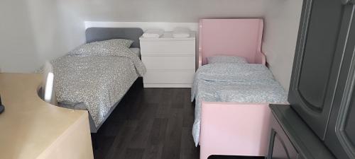 - une petite chambre avec 2 lits et un miroir dans l'établissement F3 A 400 m du Stade de France JO, à Saint-Denis