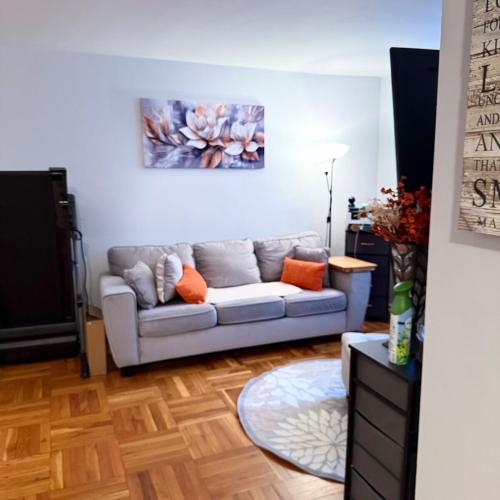 a living room with a couch and a painting on the wall at Welcome to New Rochelle Studio in New Rochelle