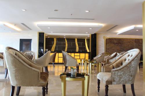 a group of chairs and tables in a lobby at Swiss-Belhotel Makassar in Makassar