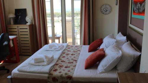 a bedroom with a bed with white sheets and red pillows at Constantin in Dhémbla