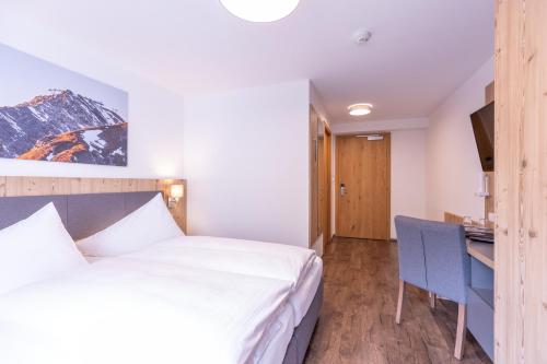 a hotel room with a bed and a desk at Haus Sattelblick in Sankt Anton am Arlberg