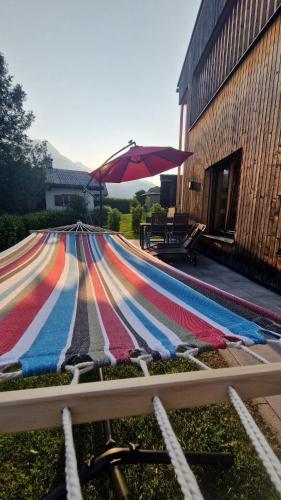 a colorful rug next to a building with an umbrella at Haus Albuin in Sankt Gallenkirch