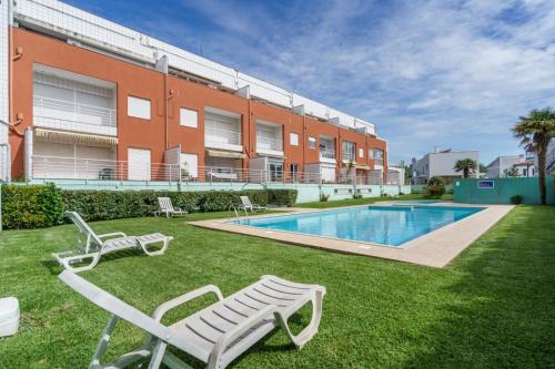 a yard with two chairs and a swimming pool at Ofir Beach Lodge by Minho's Guest in Fão