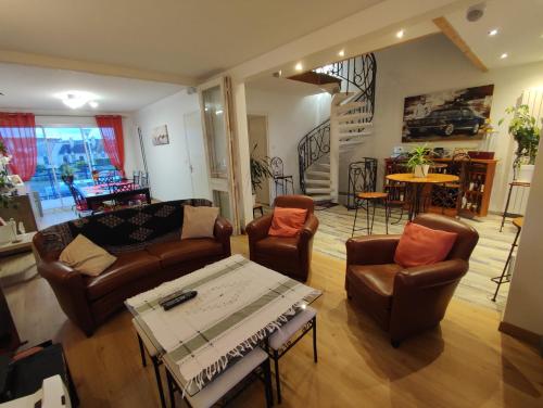 a living room with a couch and chairs and a table at Face a la mer in Courseulles-sur-Mer