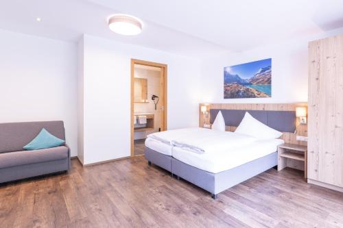 a hotel room with a bed and a couch at Haus Sattelblick in Sankt Anton am Arlberg