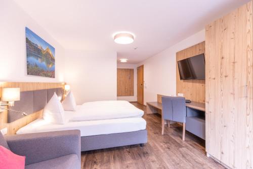 a hotel room with two beds and a desk at Haus Sattelblick in Sankt Anton am Arlberg