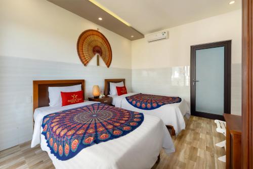 a hotel room with two beds and a window at Blessing Villa Hoi An in Hoi An