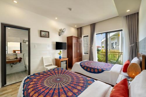 a hotel room with two beds and a balcony at Blessing Villa Hoi An in Hoi An