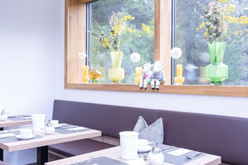 a dining room with two tables and vases on a window at Haus Sattelblick in Sankt Anton am Arlberg