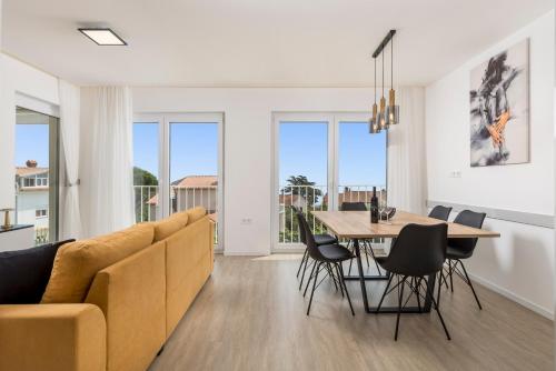 a living room with a couch and a table and chairs at Apartment in Villa Marealto with pool, garage and seaview in Ičići
