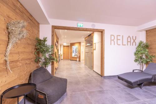 a lobby with chairs and a hallway with a relapse sign on the wall at Haus Sattelblick in Sankt Anton am Arlberg