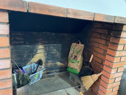 a brick fireplace with a paper bag and other items at Casa Erundina in Camariñas