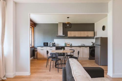 a kitchen and living room with a table and chairs at Chamalières Appartement moderne pour 5 personnes in Chamalières