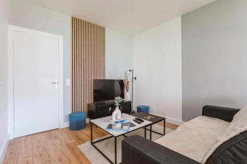 a living room with a couch and a table at Chamalières Appartement moderne pour 5 personnes in Chamalières