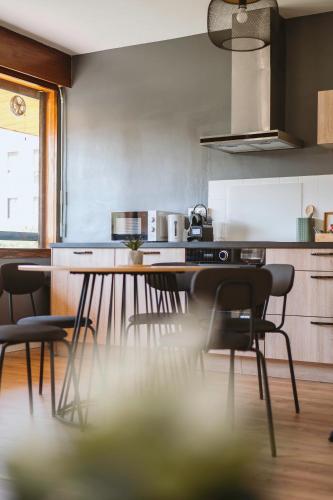 a kitchen with a table and chairs in it at Chamalières Appartement moderne pour 5 personnes in Chamalières